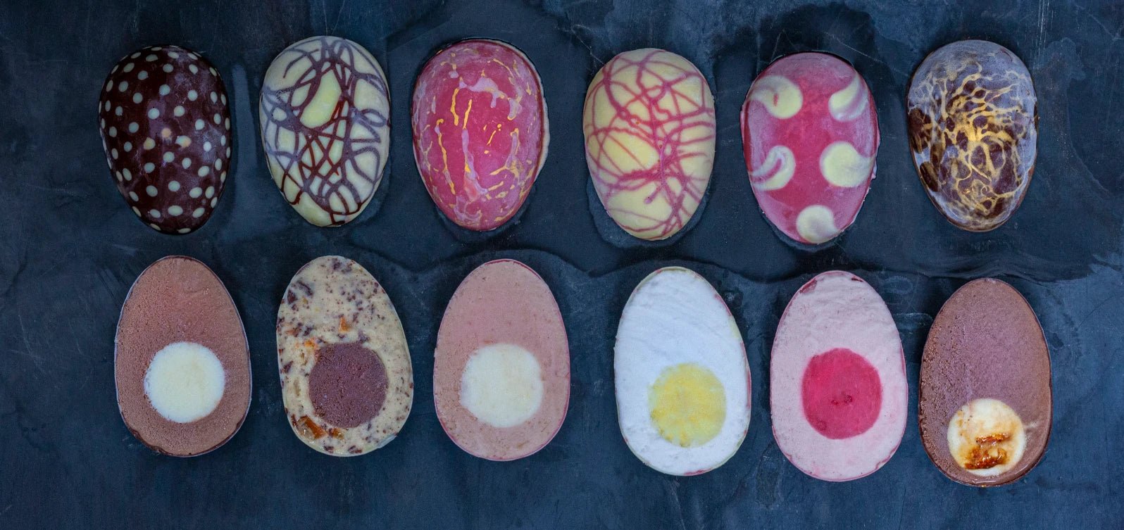The Ruby Violet Ice cream Easter eggs cut in half and shot from above, against a dark background.