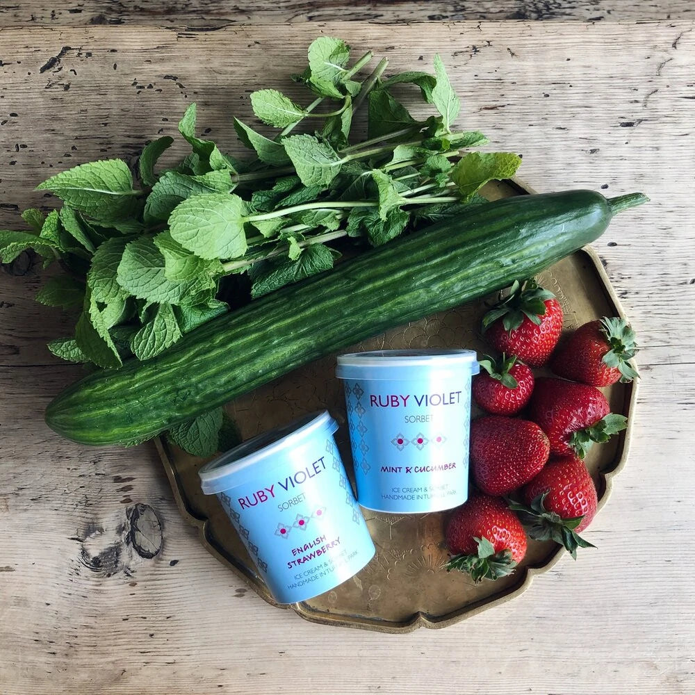 Mint and cucumber and English Strawberry sorbet tiny tubs on a tray with fresh cucumbers, mint and strawberries