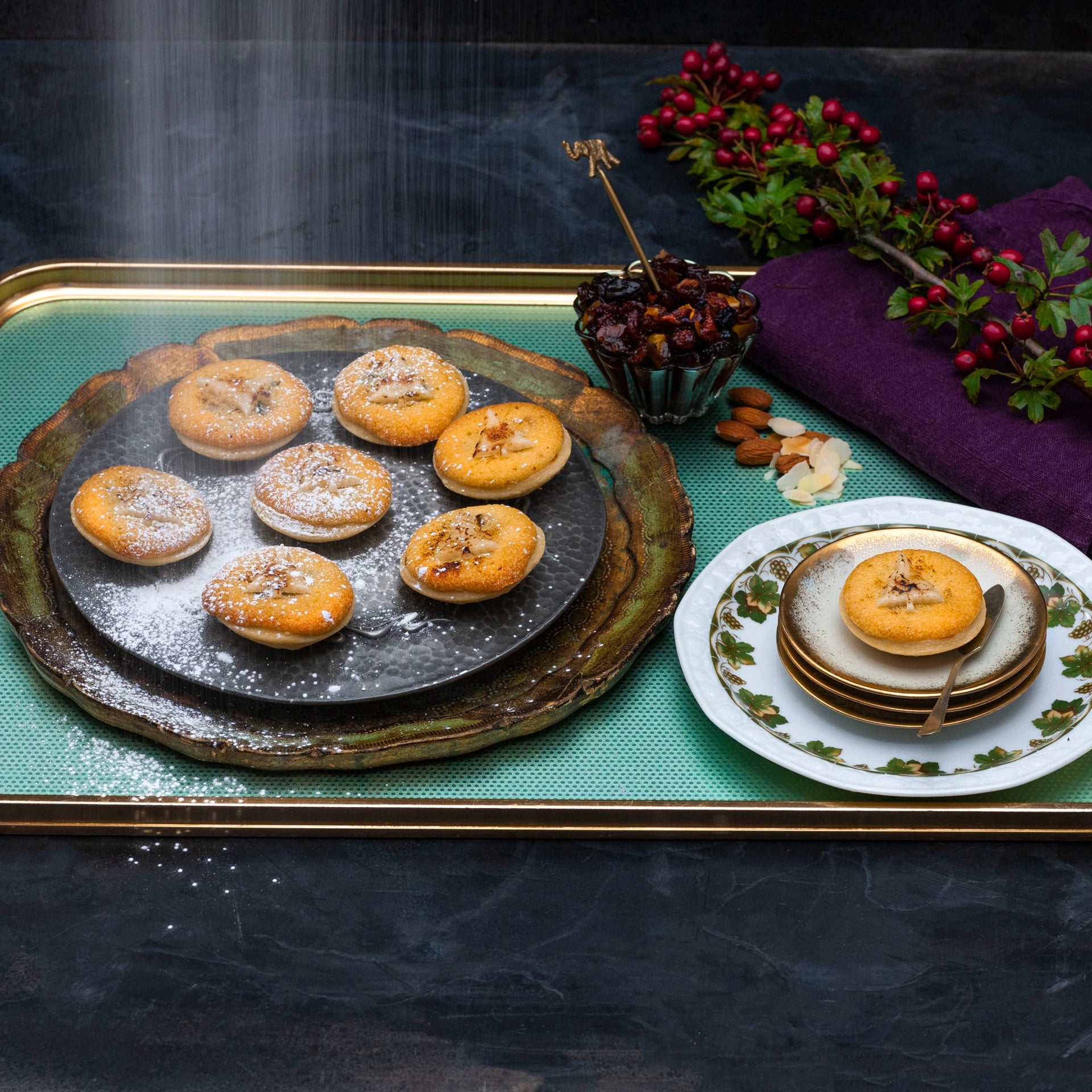 Handmade Frangipane topped minced pies on a tray, topped with icing sugar