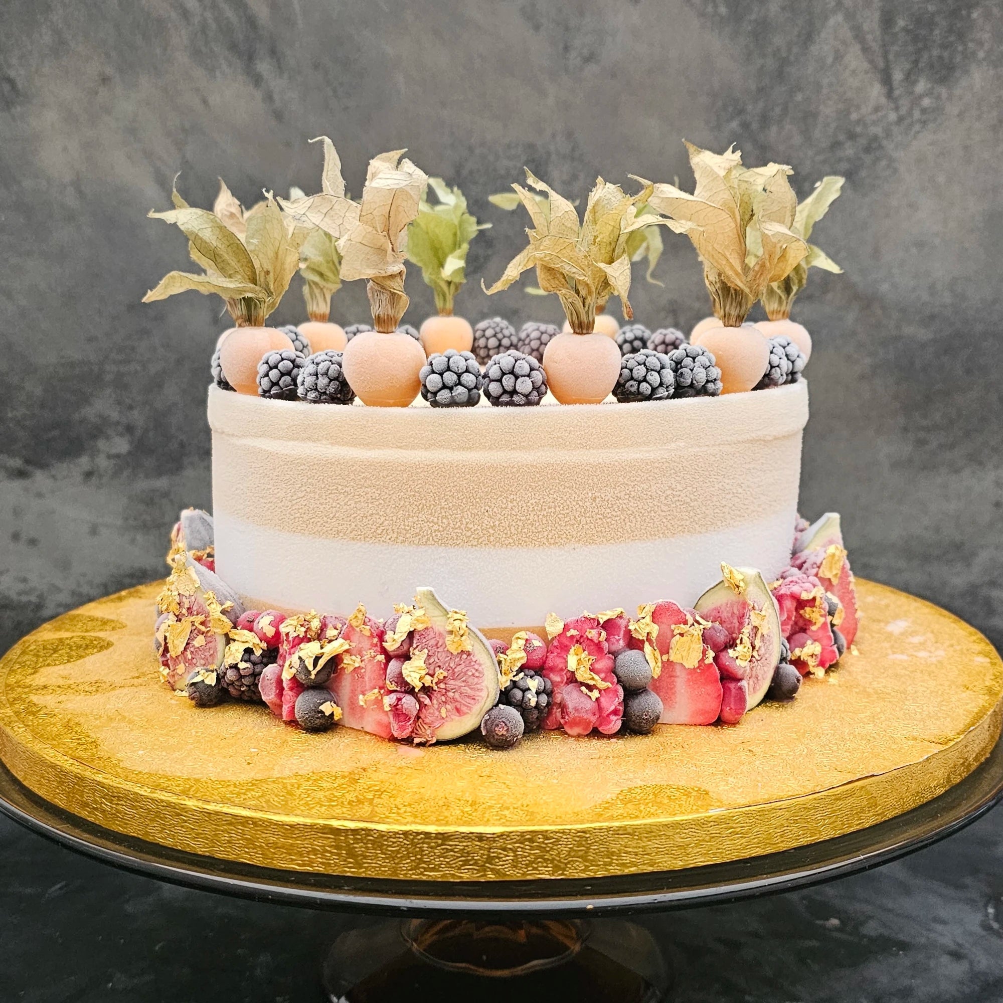 50th birthday cake decorated with frozen fruits and gold.