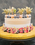 50th birthday cake decorated with frozen fruits and gold.