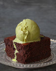 Chocolate brownie with a scoop of ice cream on a decorative plate against a dark background