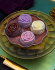Four ice cream roses in chocolate, raspberry, blackcurrant and milk ice cream on a copper tray