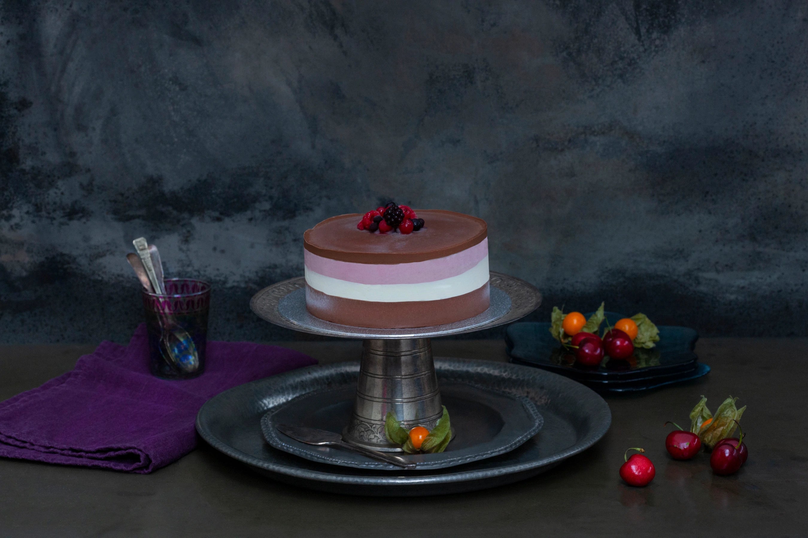 Handmade ice cream layer cake with three layers, chocolate ganache top and fruit decoration