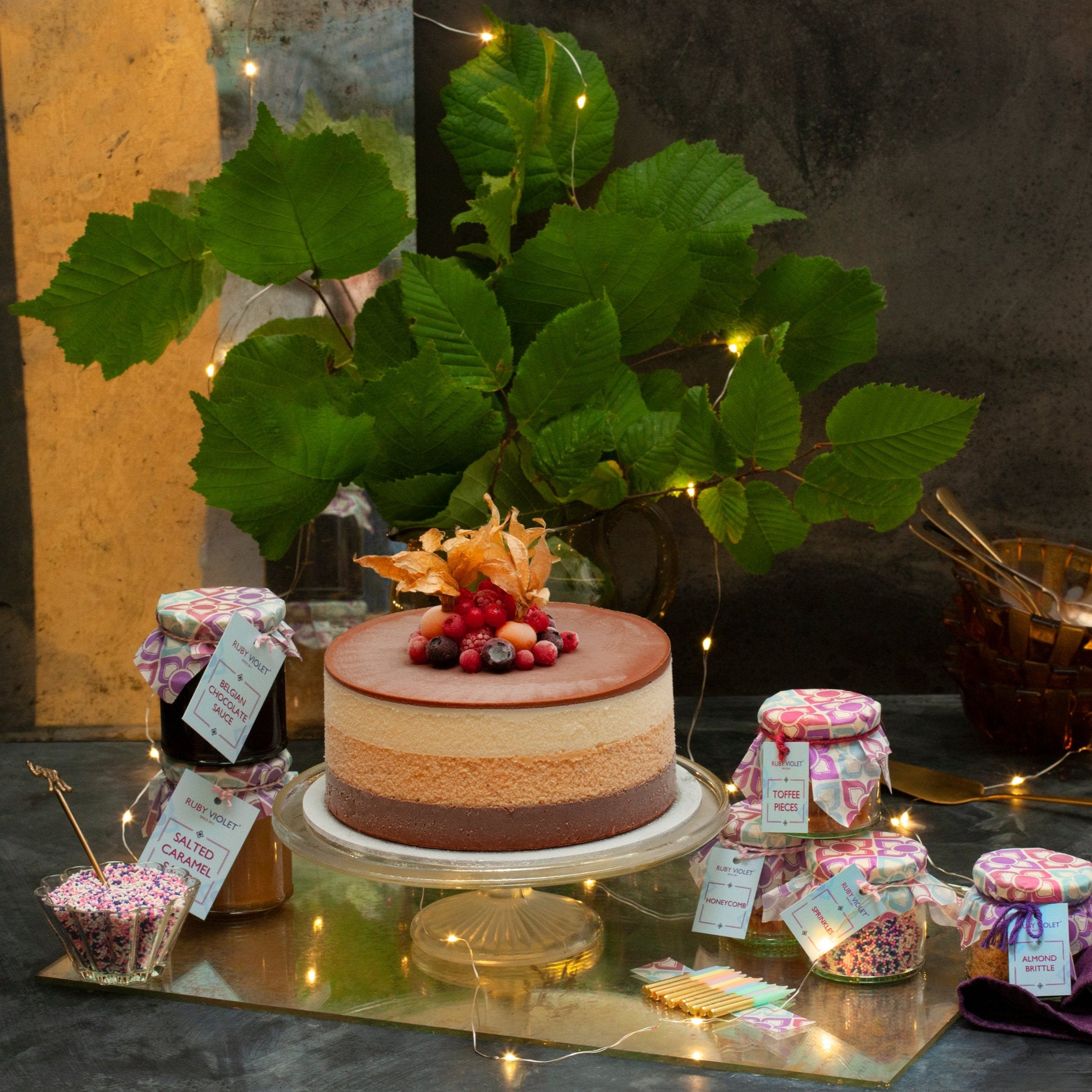Uncle Horace ice cream cake surrounded by jars of toppings and sauces