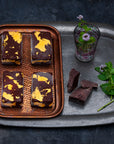 Four gold mint chocolate bars on a tray with fresh mint and dark chocolate