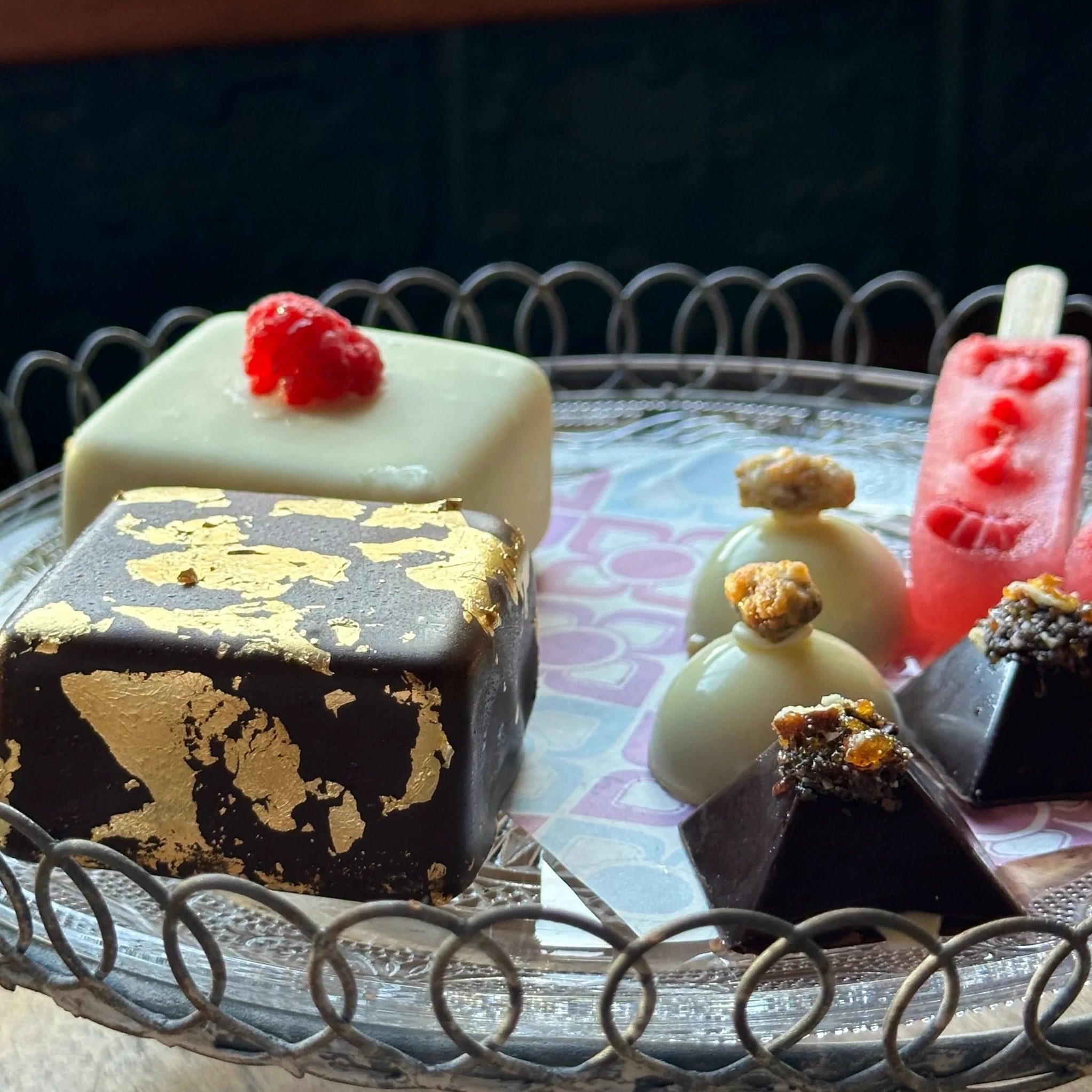 Mini ice cream cakes and ice cream chocolates decorated with gold, nuts and berries