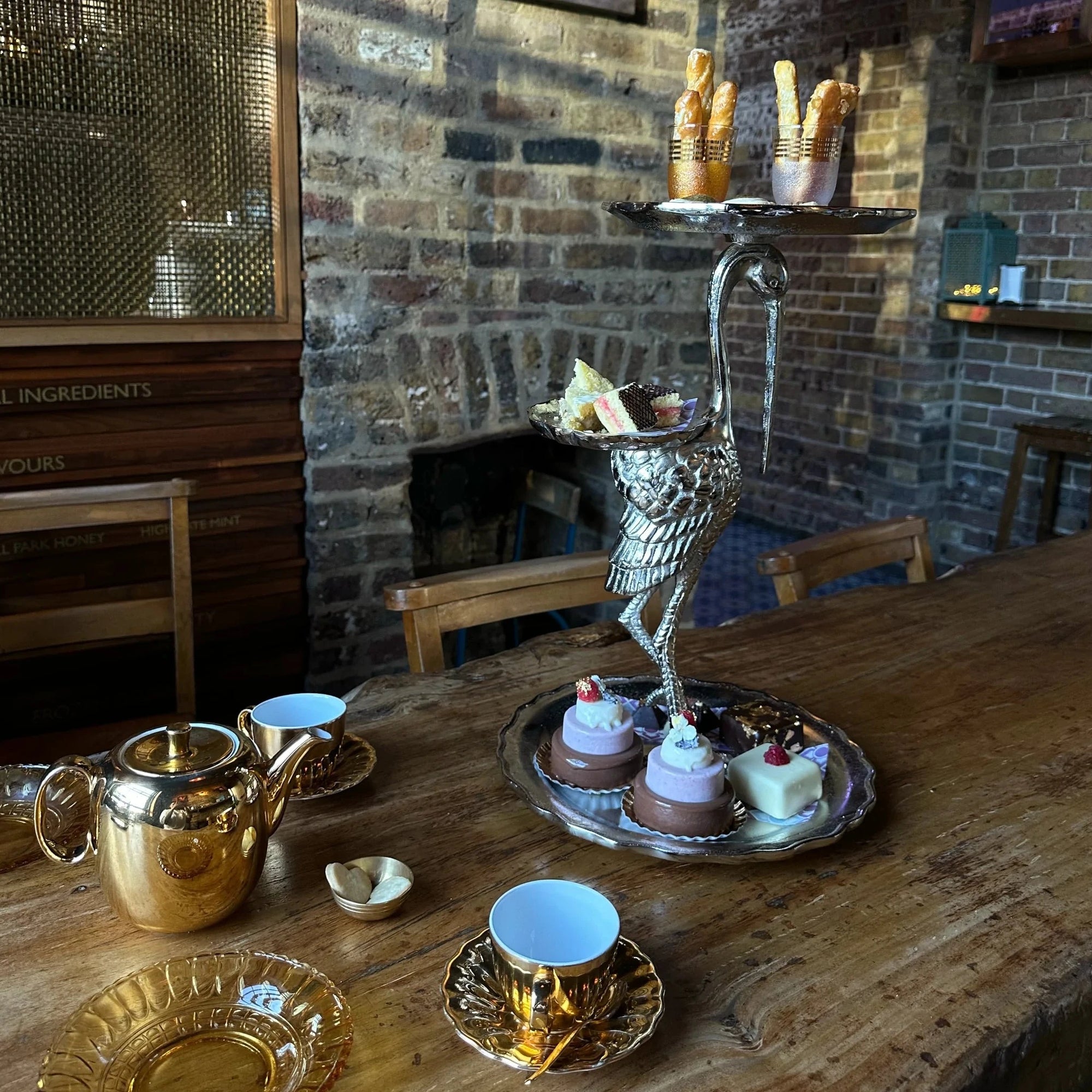 The ice cream afternoon tea layed out on a bird shaped stand. Served with tea in golden china.