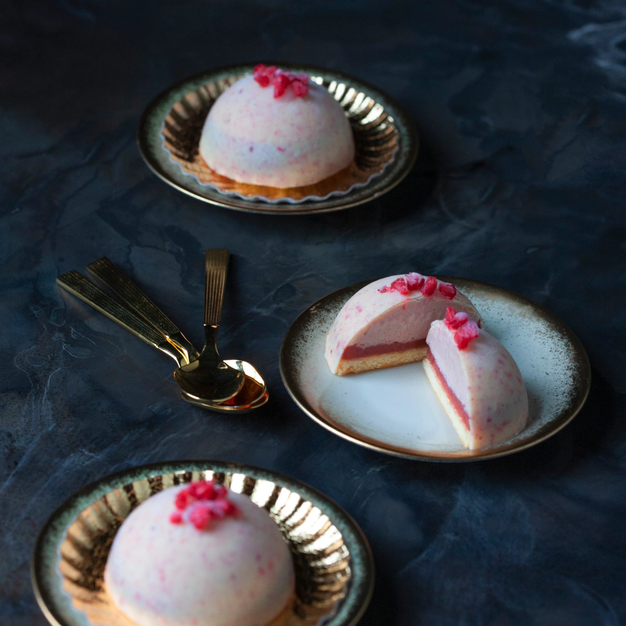 Mini raspberry bombes on golden plates
