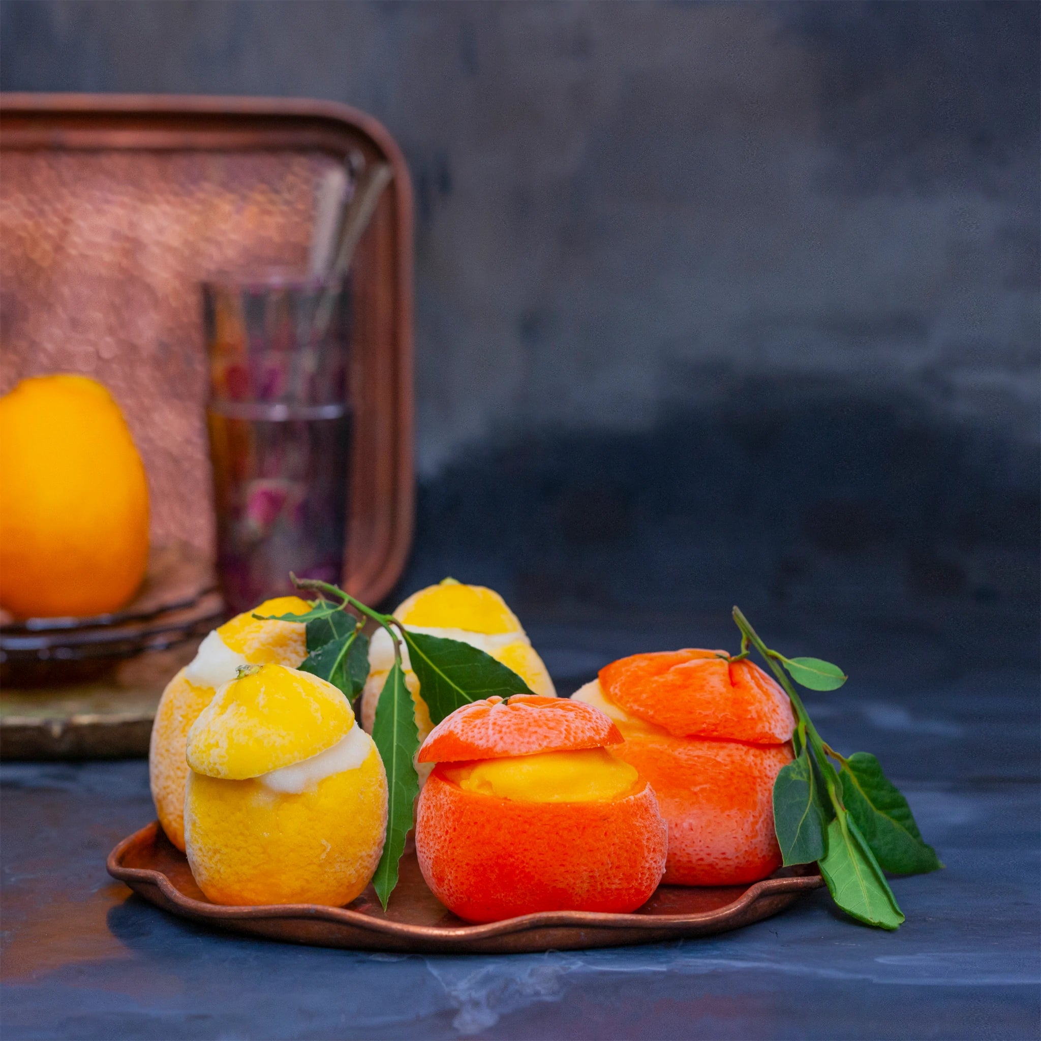 Sorbet filled lemons and clementines on a tray