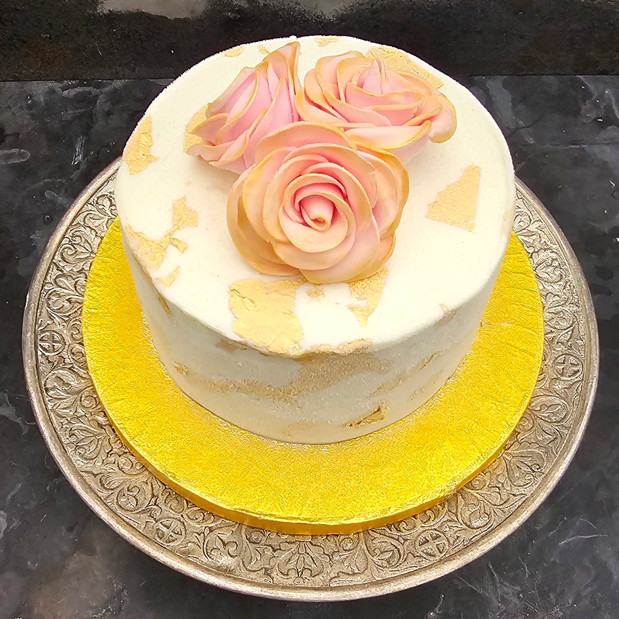 Bespoke wedding cake decorated with gold and roses