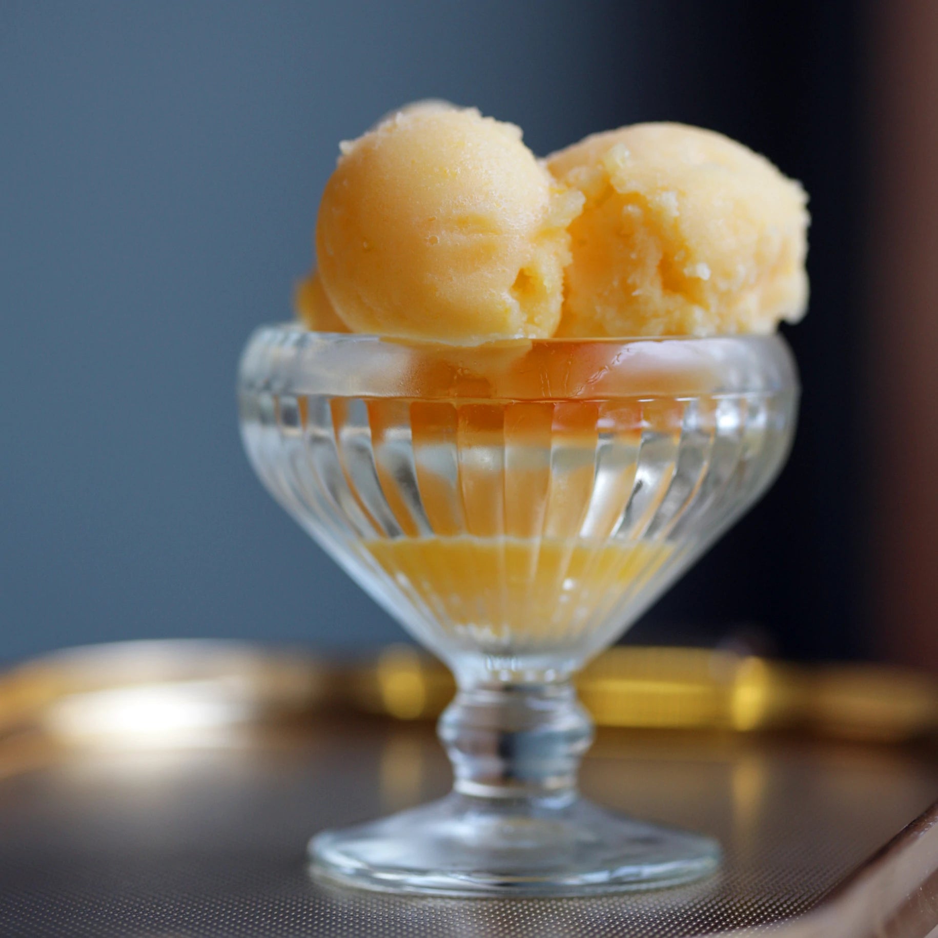 Scoops of clementine sorbet in a glass cup