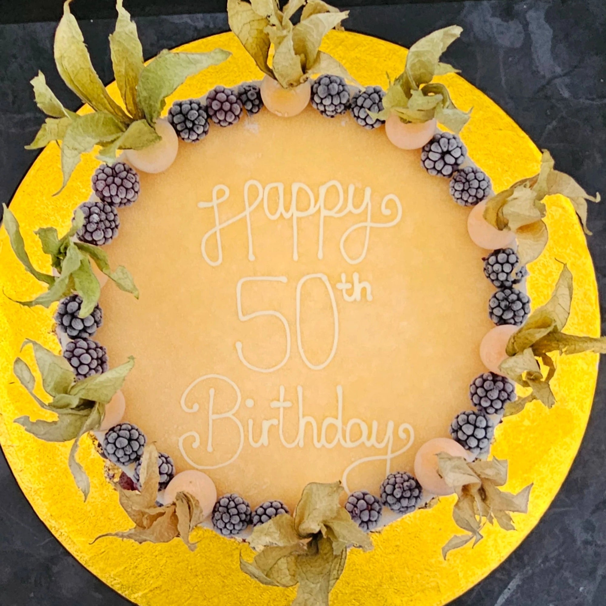 50th birthday cake decorated with blackberries and physalis