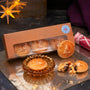 Box of frangipane mince pies with a window, one is on a glass plate, and another broken open on a reflective surface.