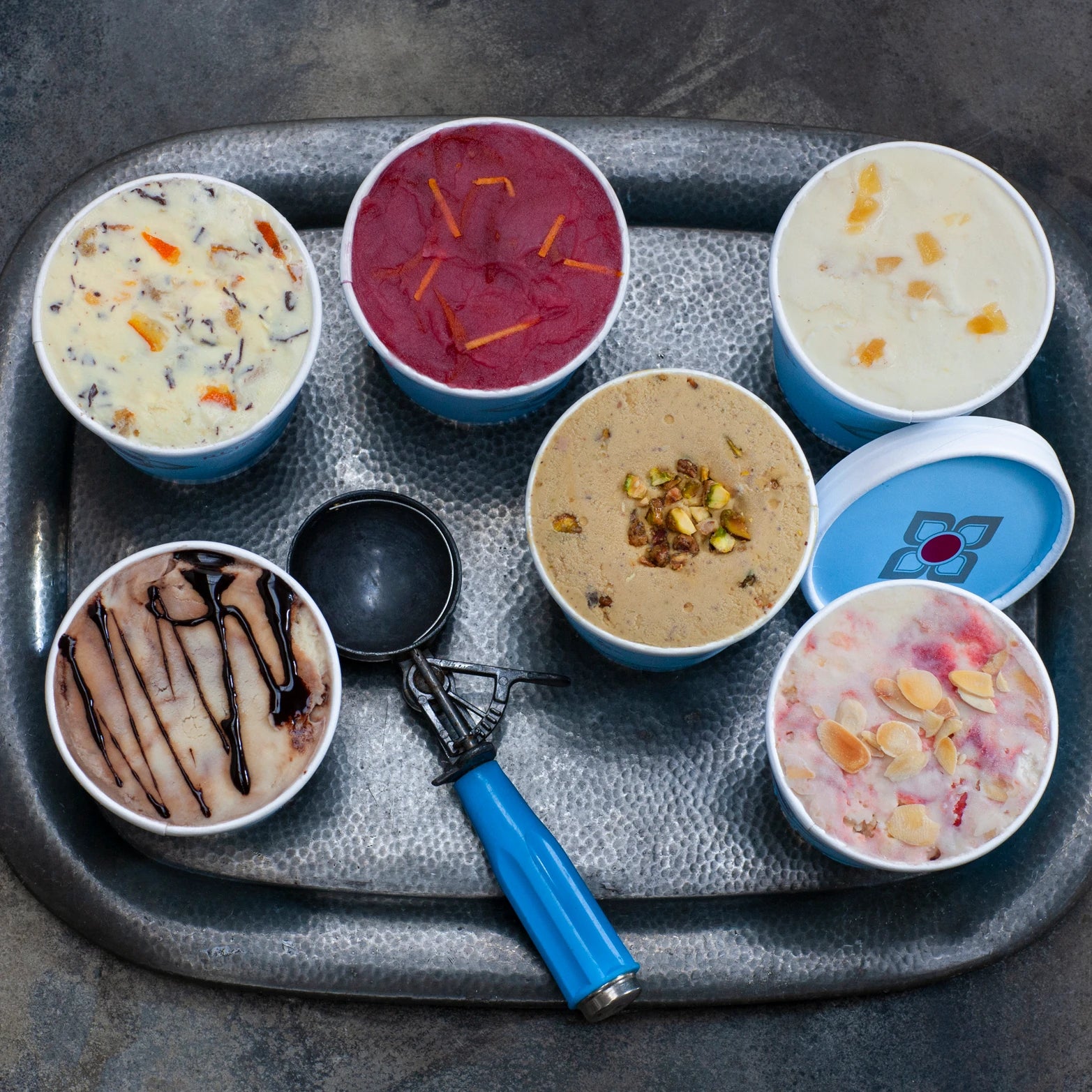 Medium tubs of ice cream and sorbet on a tray