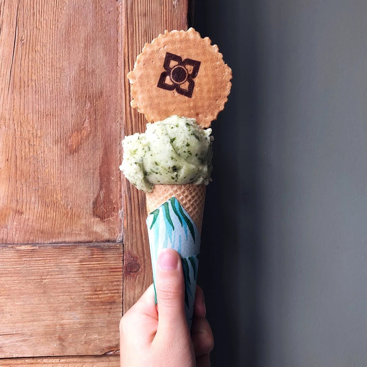 Scoop of mint and cucumber sorbet on a cone with a wafer