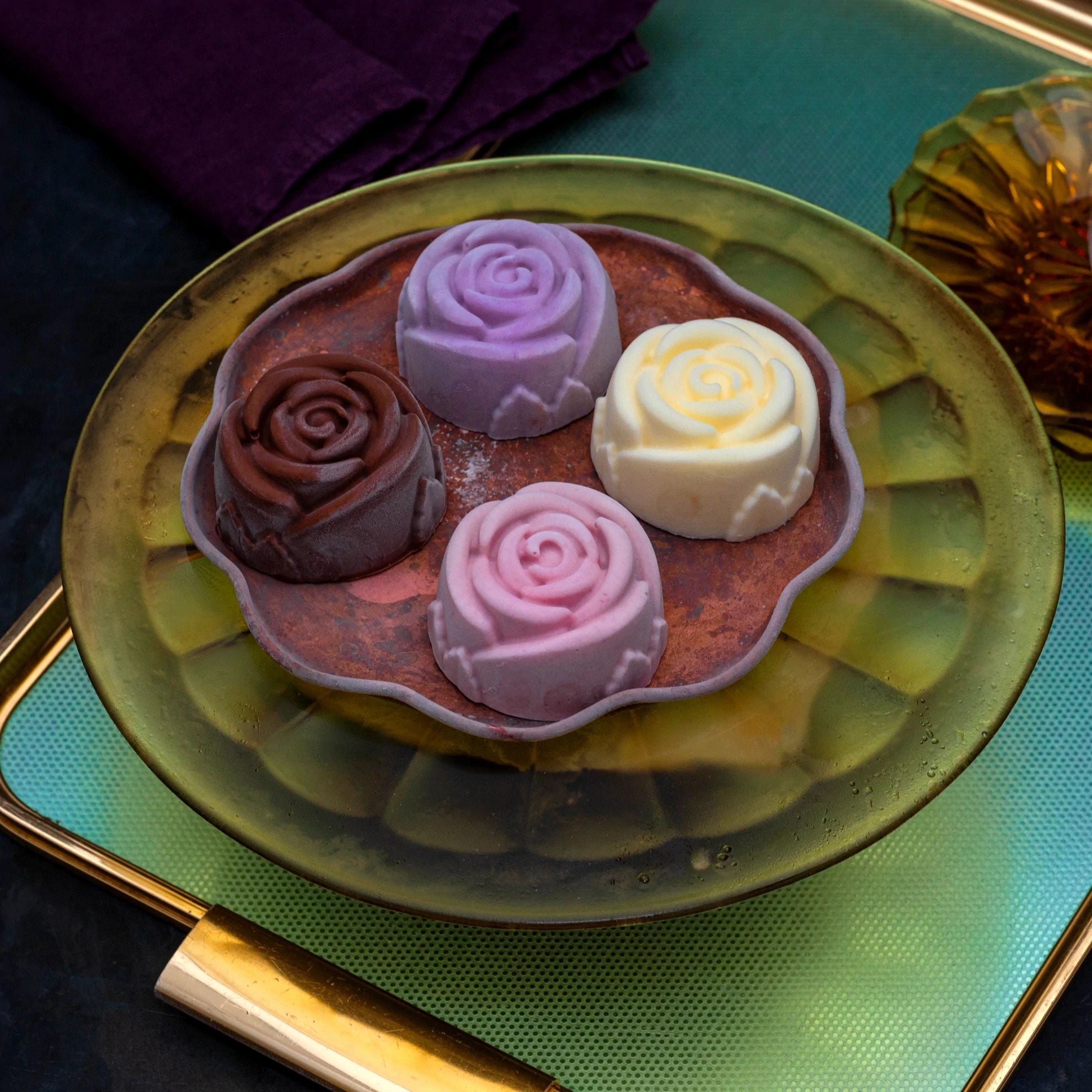Four ice cream roses in chocolate, raspberry, blackcurrant and milk ice cream on a copper tray