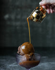 Maldon Salt caramel sauces being poured over a scoop of ice cream from a little golden jug