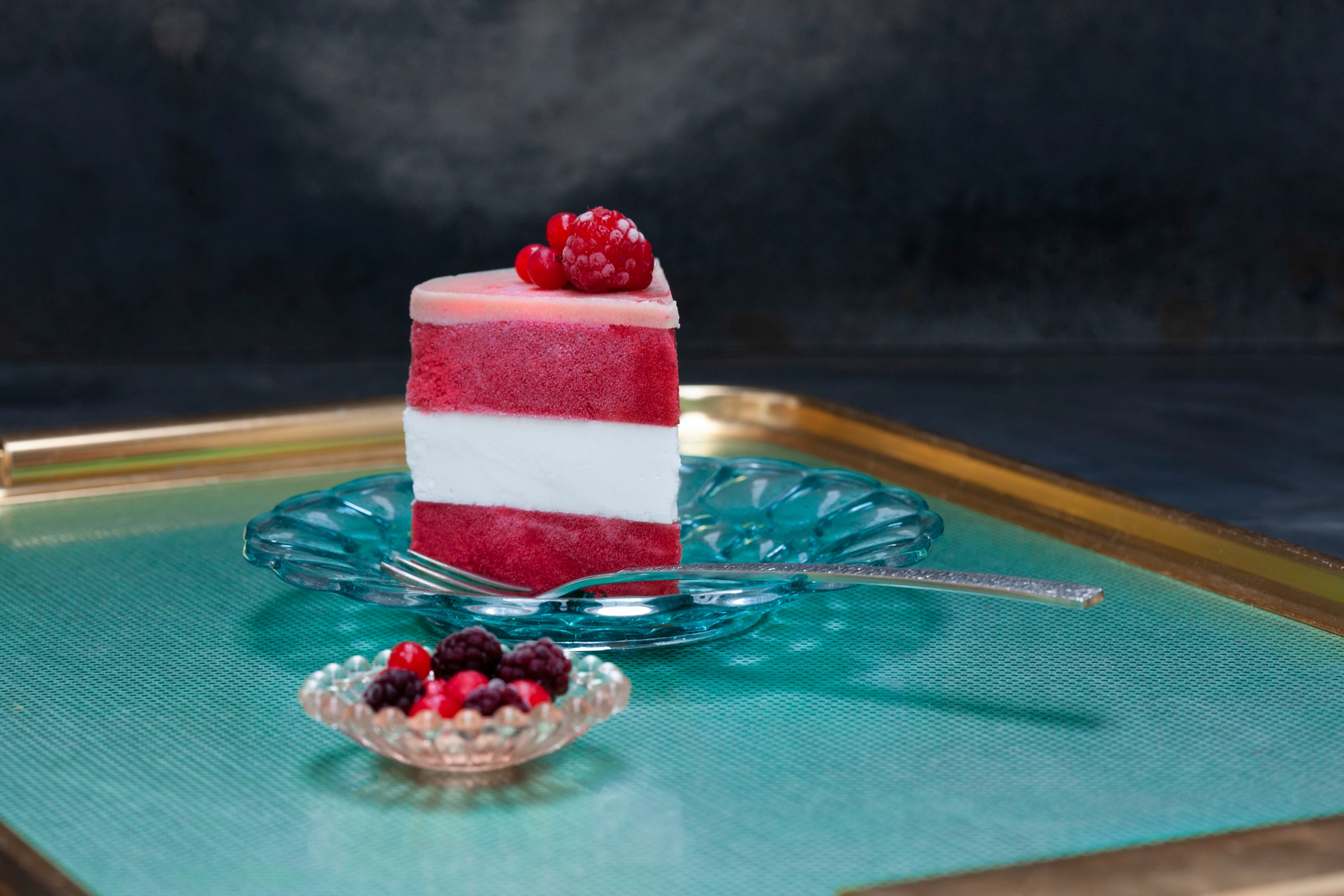 A slice of handmade vegan raspberry and coconut cake on a plate with a fork