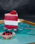 A slice of handmade vegan raspberry and coconut cake on a plate with a fork